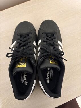 Adidas Superstars Black Sneakers with White Stripes and Gold Tongue Logo